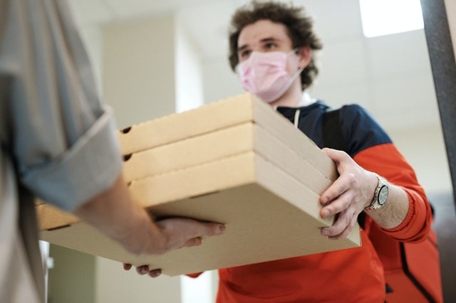 man wearing face mask delivering pizza