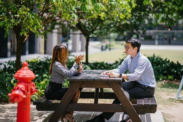 man sitting on chair in front of woman