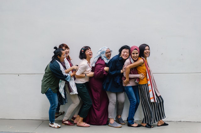 women falling in line holding each other